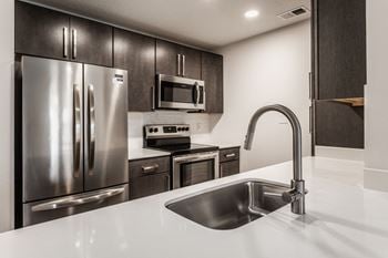 A kitchen with stainless steel appliances and a white counter top